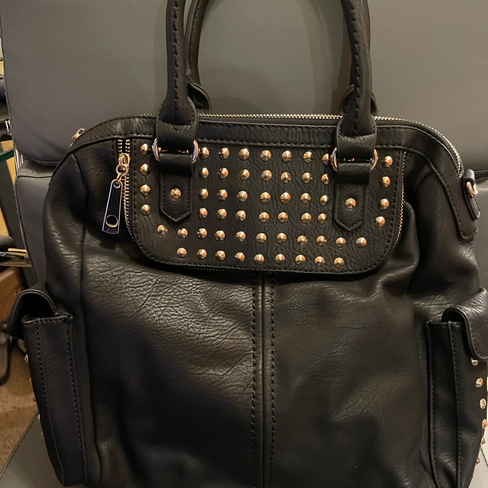 new black leather hand bag with gold studs.